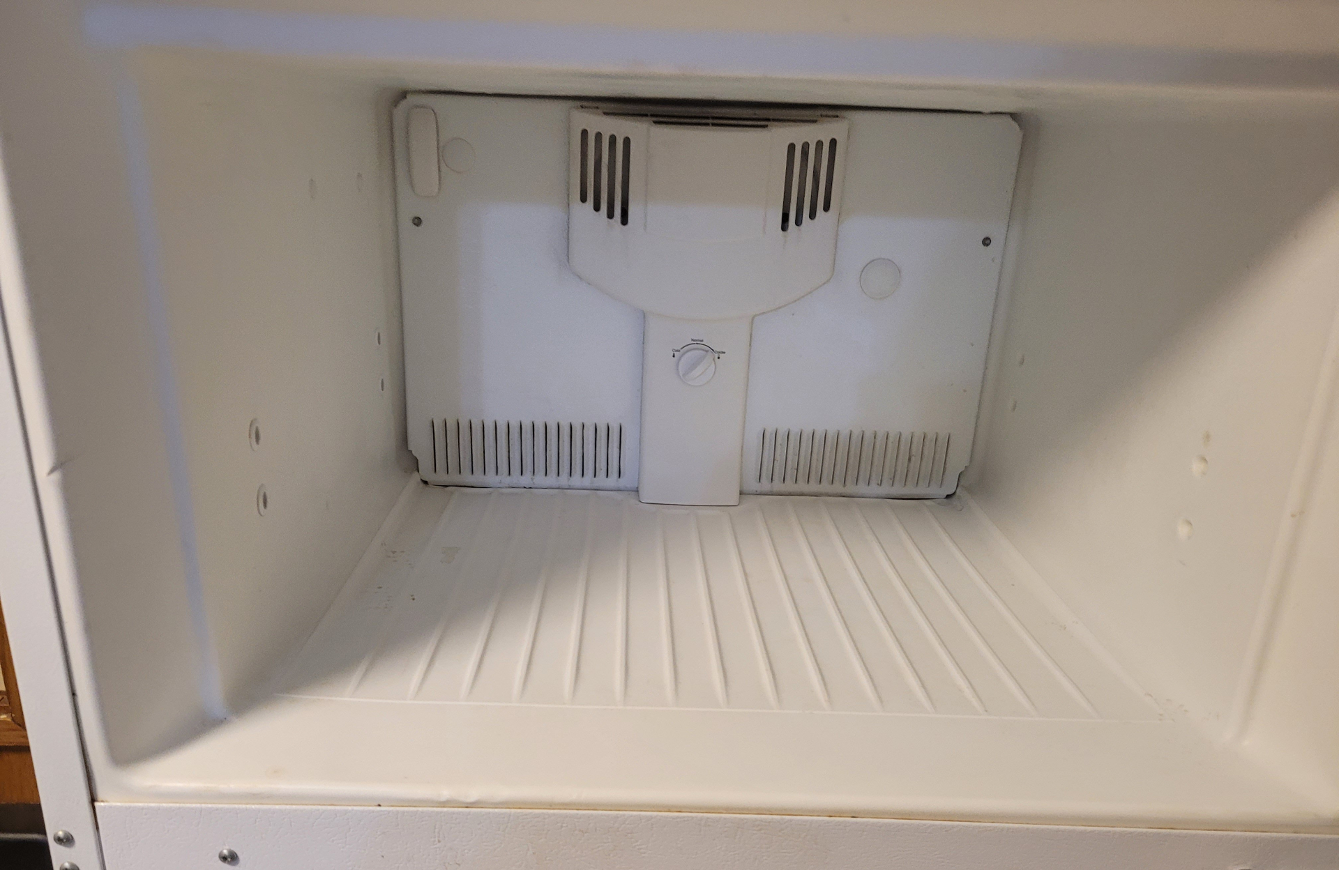 Clean refrigerator interior after move-out cleaning